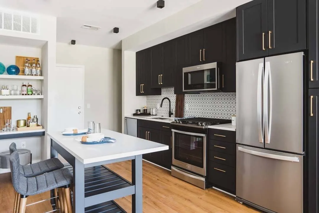 Kitchen with dark cabinets and tall ceilings with open shelving and moveable kitchen island