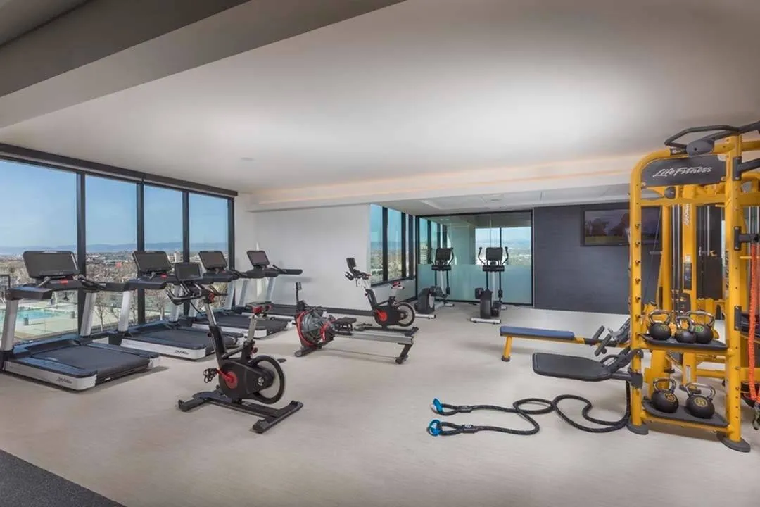 Weight and cardio stations with a view over the pool and skyline