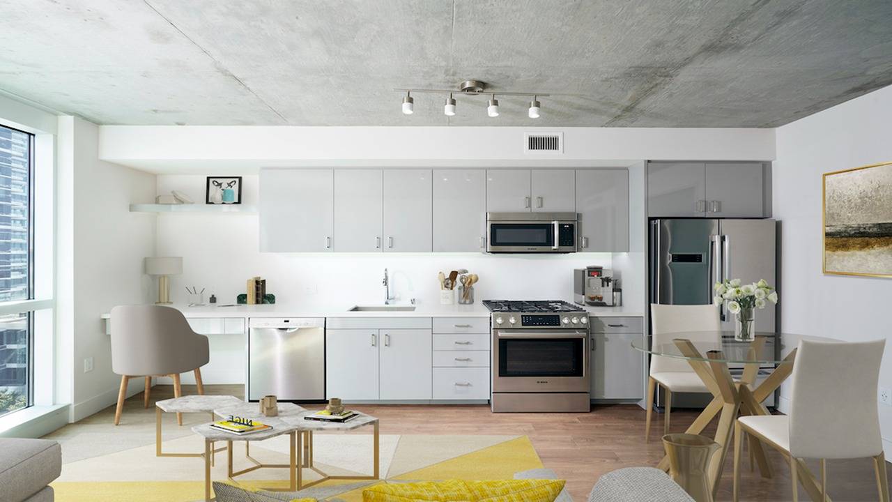 Wood plank flooring and concrete ceilings are featured along with stunning stainless steel appliances and a gas range