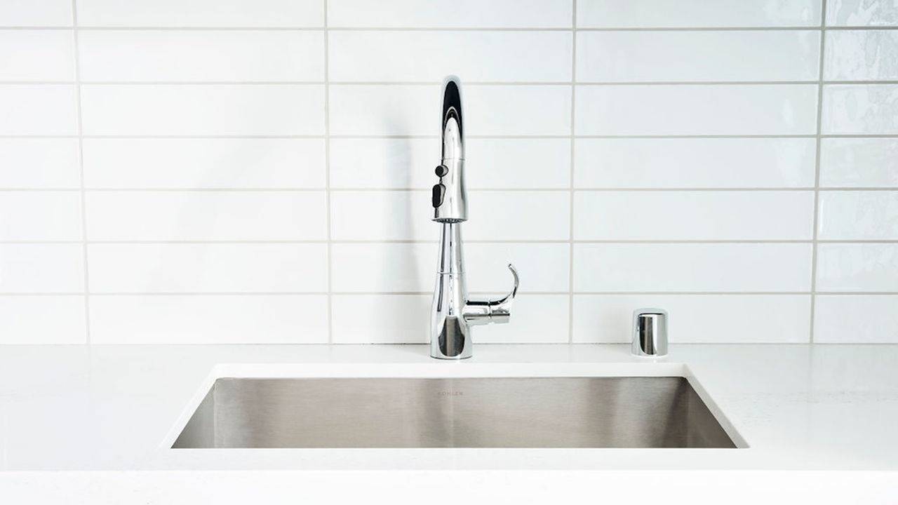 White subway tile and white quartz countertops with stainless steel sink and chrome pull-down faucet