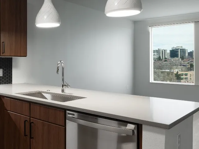 Kitchen faucet close up showing pendant lighting and living room