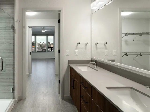 Double vanity shown in bathroom looking out to bedroom