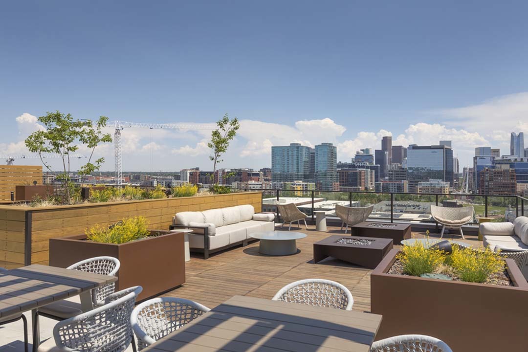 Private rooftop deck with lush landscaping, fire pits, outdoor tv, green space, and modern lounge seating to enjoy city and mountain views