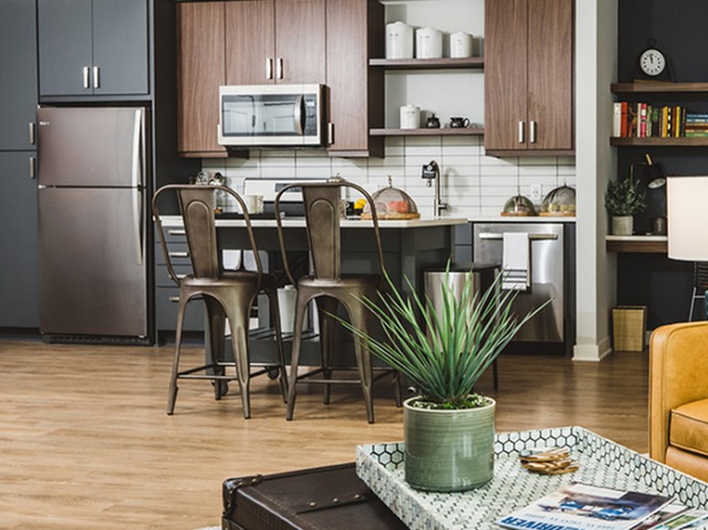 Two-tone kitchen with open shelving, island, and wood-plank style flooring