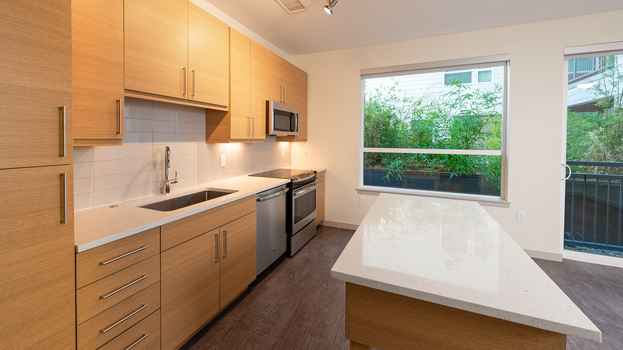 Open concept kitchen with quartz counter tops and large subway tile back splash