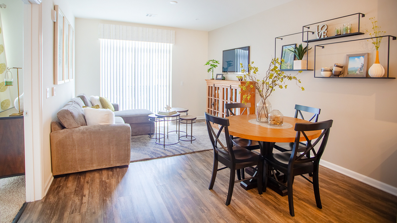 Dining area into the brightly lit living area featuring sliding glass doors