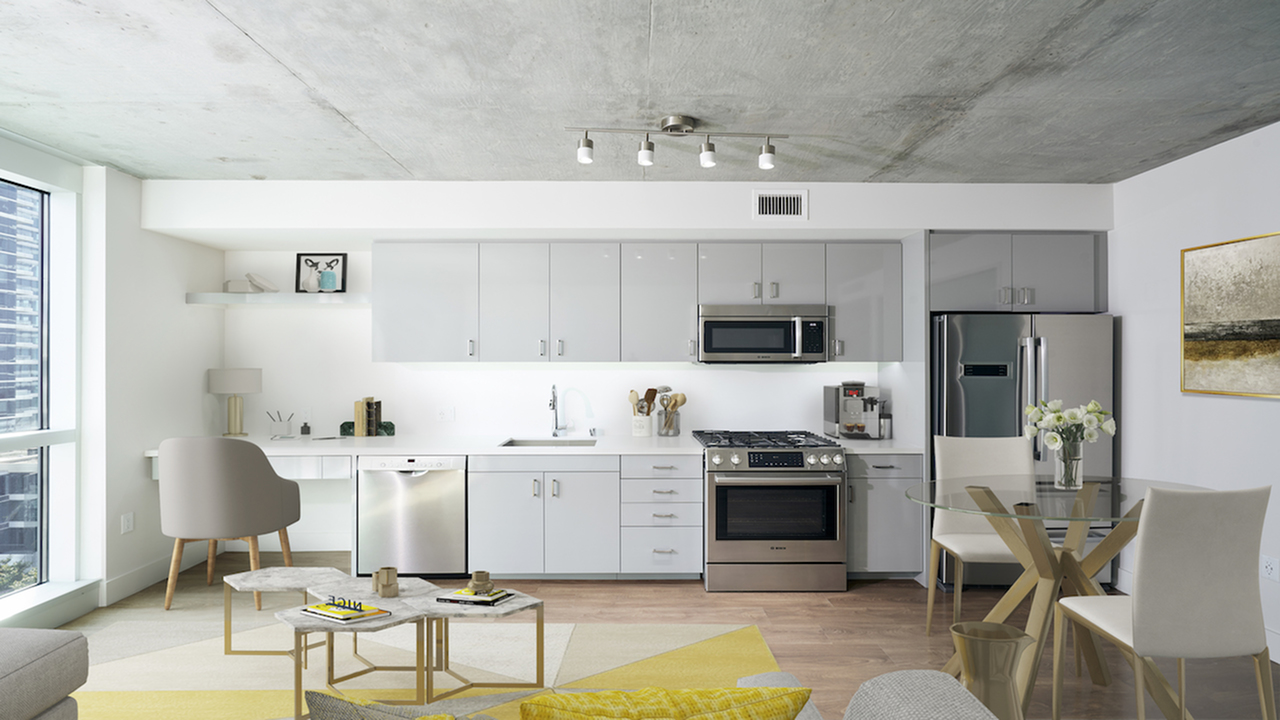 Chic apartment home with custom cabinetry, tile backsplash, and stainless steel appliances
