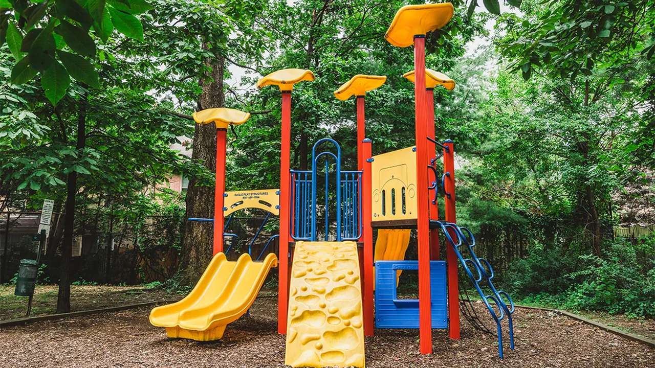 On site children\'s playscape with slides and climbing features