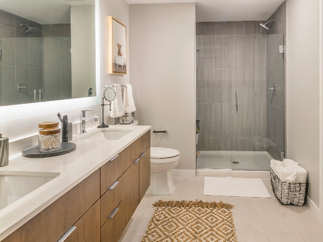 Tile bathroom floors with floor-to-ceiling tile shower, floating bathroom vanity, and frameless glass doors