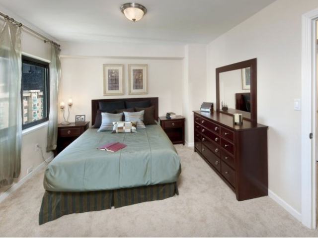 Furnished bedroom with wall-to-wall carpeting