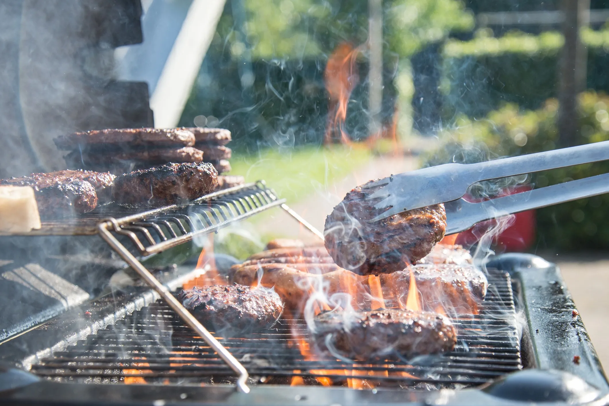 smoking grill with burgers and hot dogs cooking