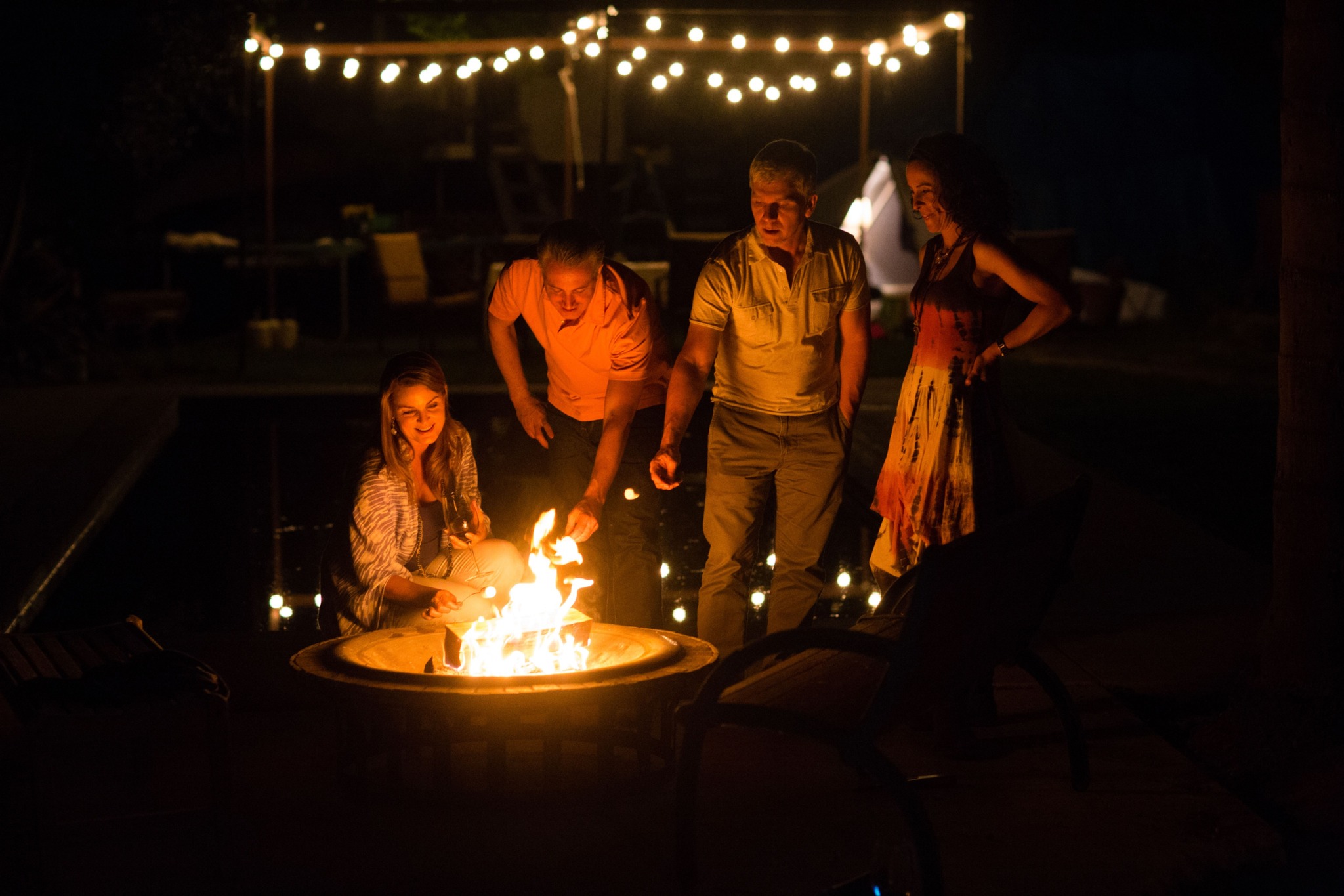friends sitting around firepit at night modera garden oaks apartment homes for rent in houton tx