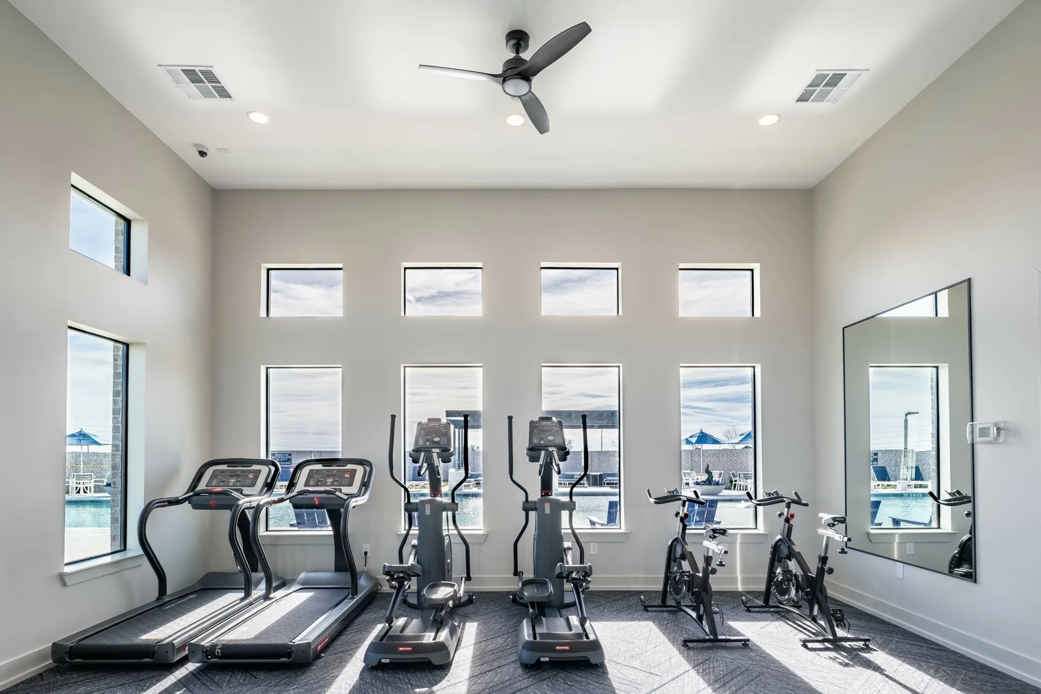 gym amenity with windows looking onto pool at amavi celina single family homes for rent in texas