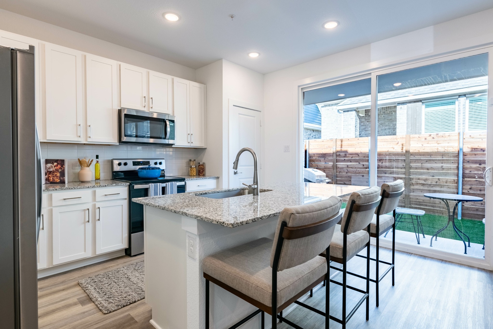 kitchen looking onto fenced in private backyard amavi celina single family homes for rent in texas