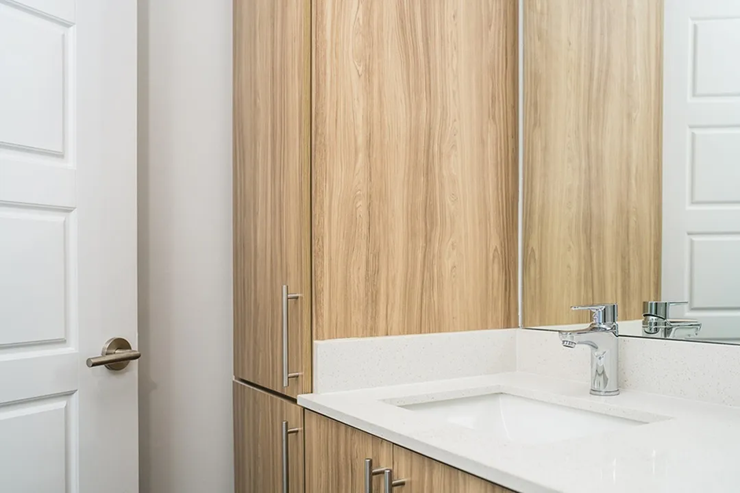 designer bathroom finishes with quartz countertops and wooden surrounds