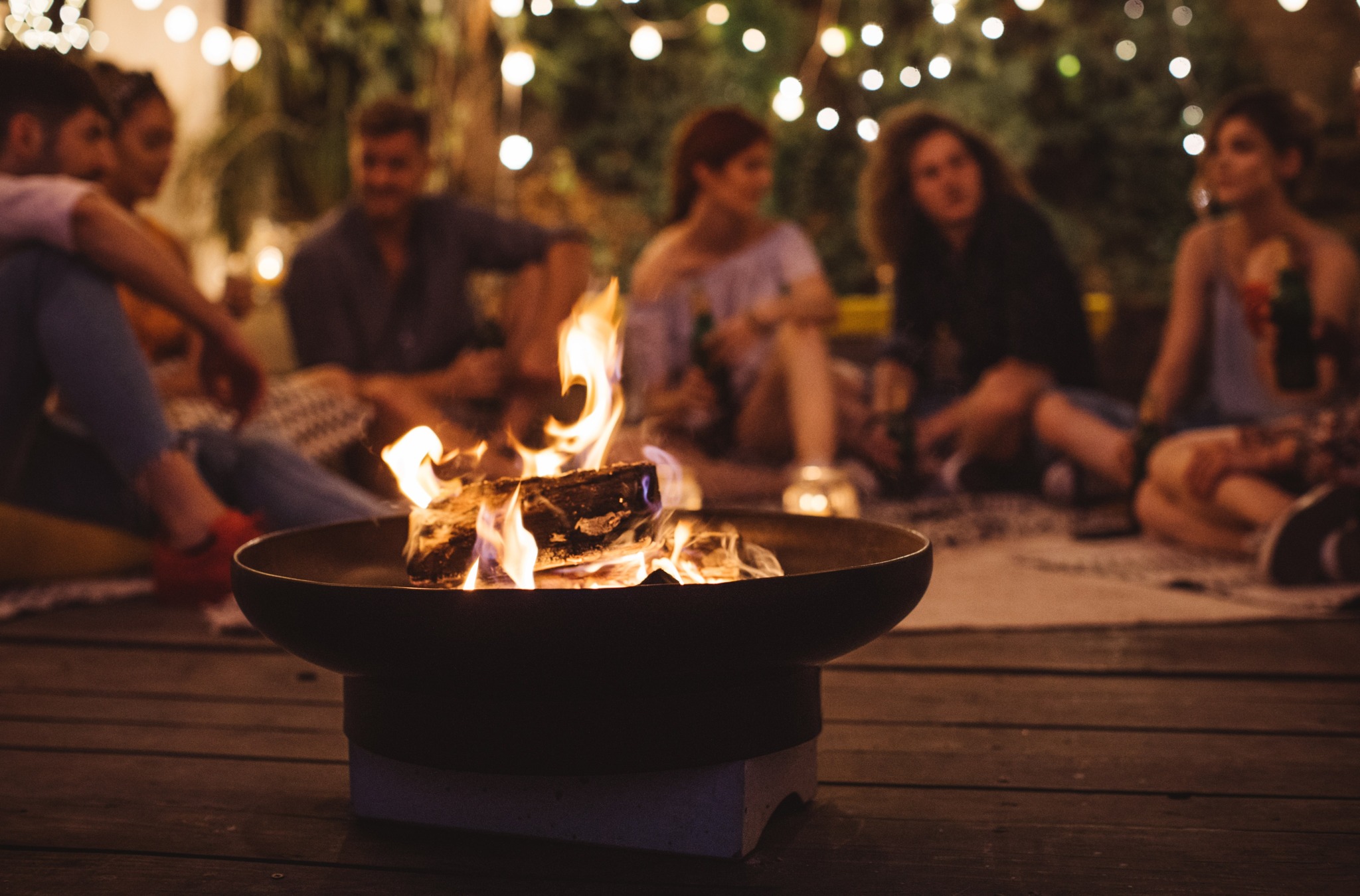 friends sitting around firepit outside modera loso apartment homes for rent in charlotte nc