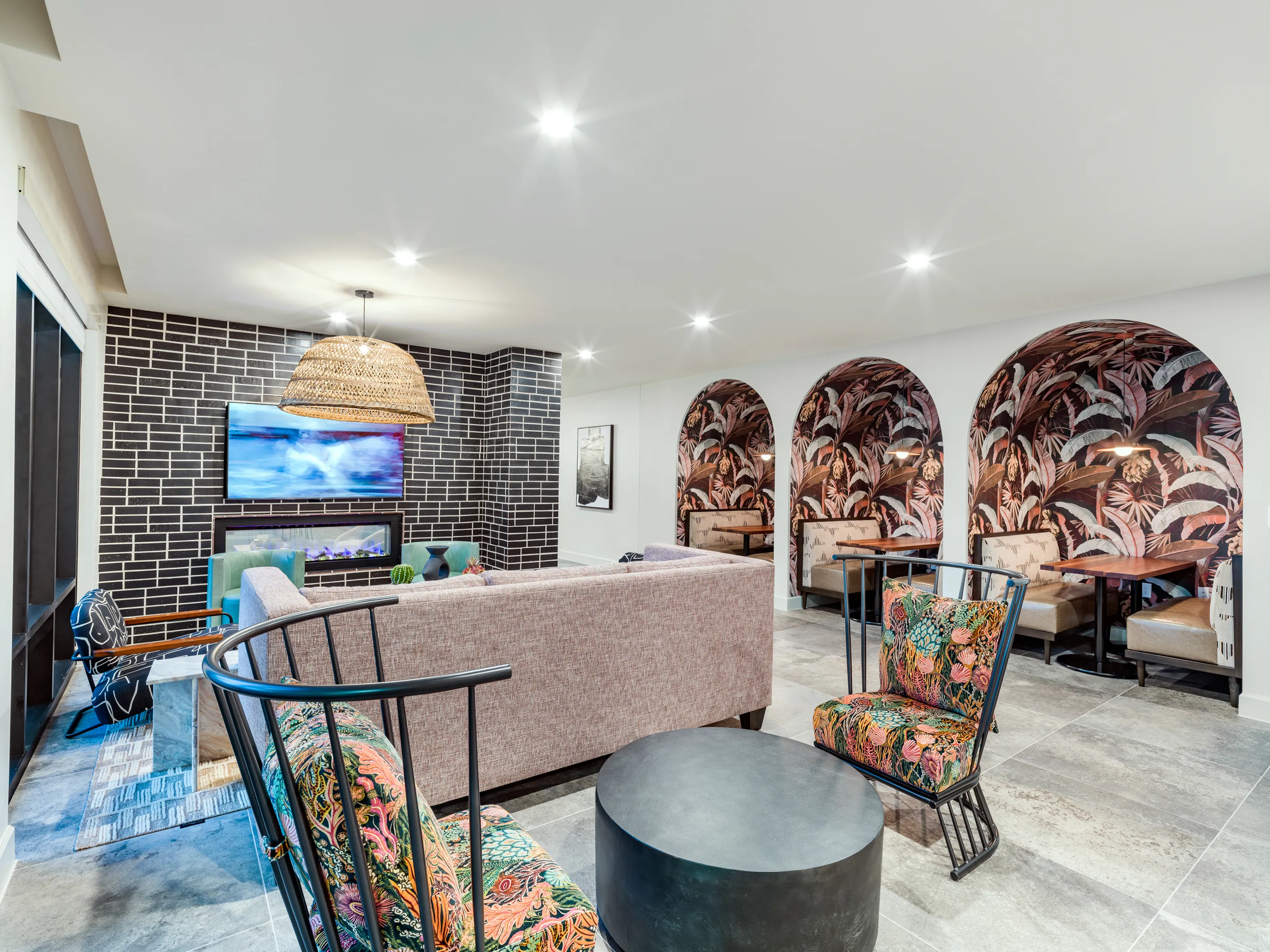 working lounge with seating, tables, tvs and more at modera trinity apartments in dallas tc