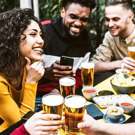 Friends having drink and food together outside Alister Lake Lynn