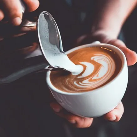person pouring coffee into latte cup modera overlake redmond washington