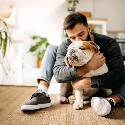 man giving dog a hug in apartment modera decatur georgia