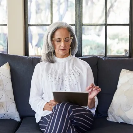 Woman sitting on couch looking at her iPad