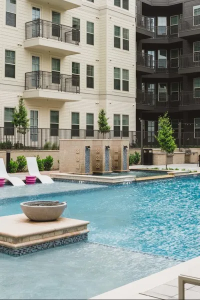 pool and sundeck with lounge seating and water features