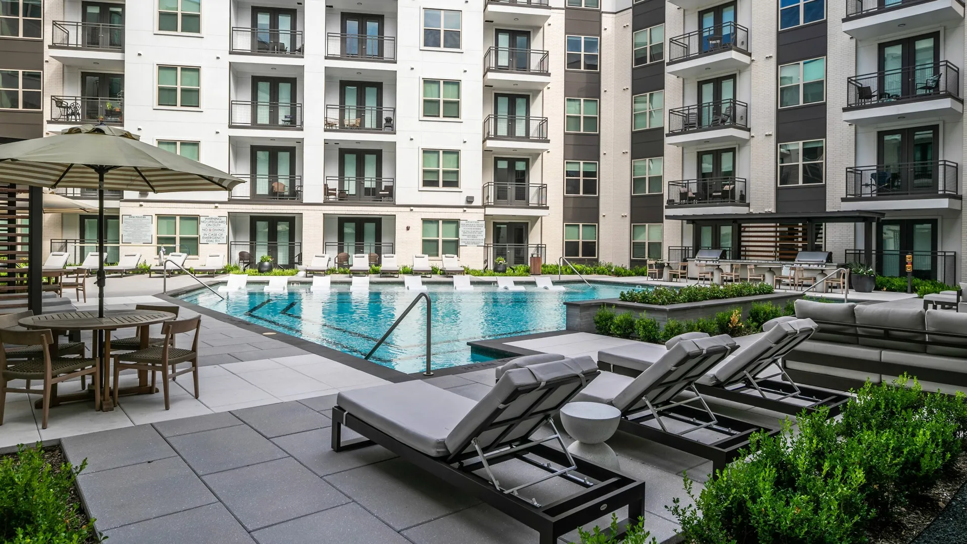 sparkling pool in courtyard with sunledge at modera six pines apartment homes for rent in texas