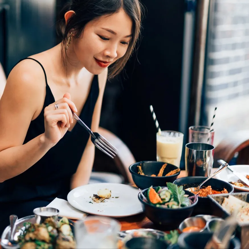 woman eating food at restaurant modera waugh apartment homes for rent in houston texas