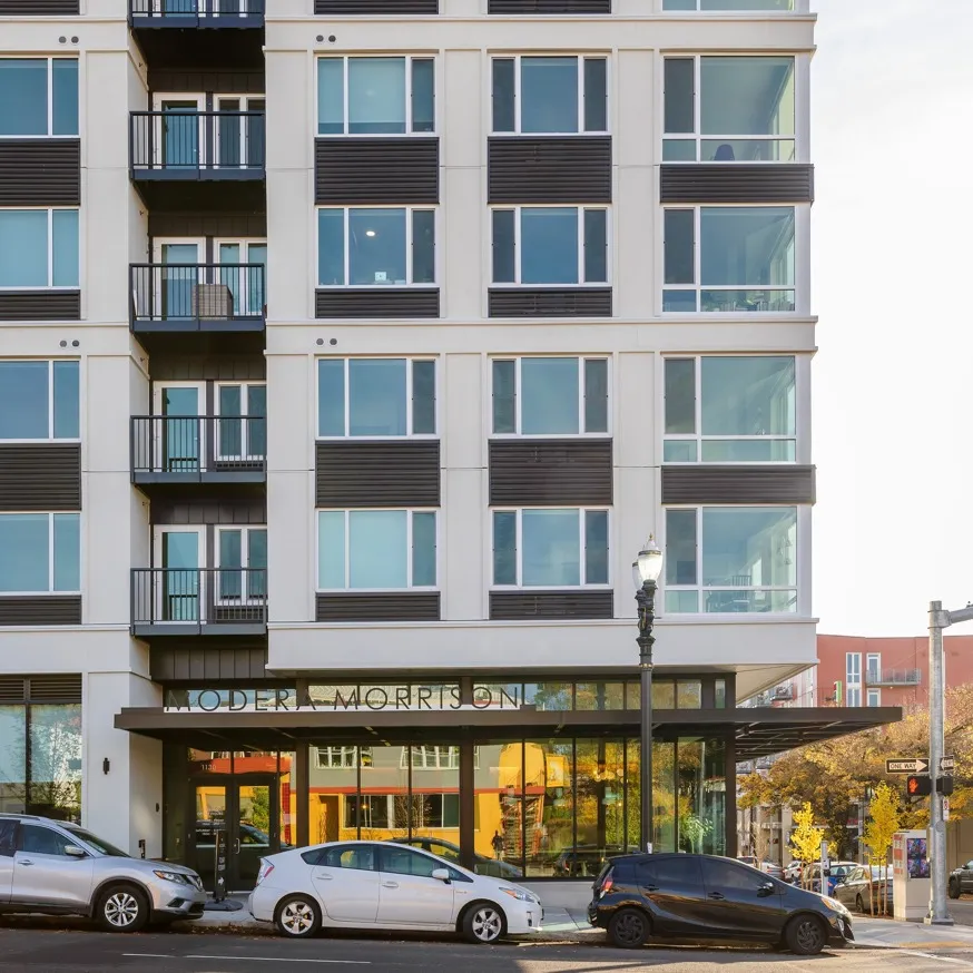 exterior of modera morrison high-rise apartments with cars parked on the street