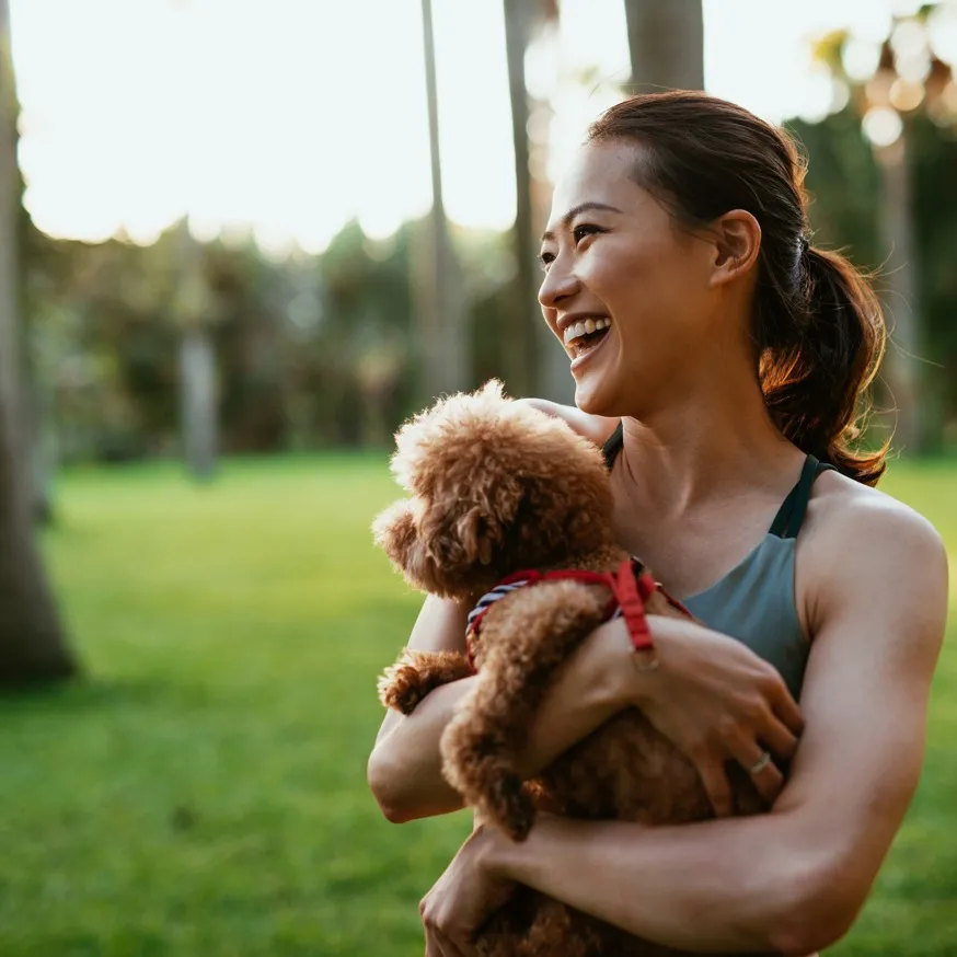 woman snuggling with dog while outisde at montville apartment homes for rent in new jersey