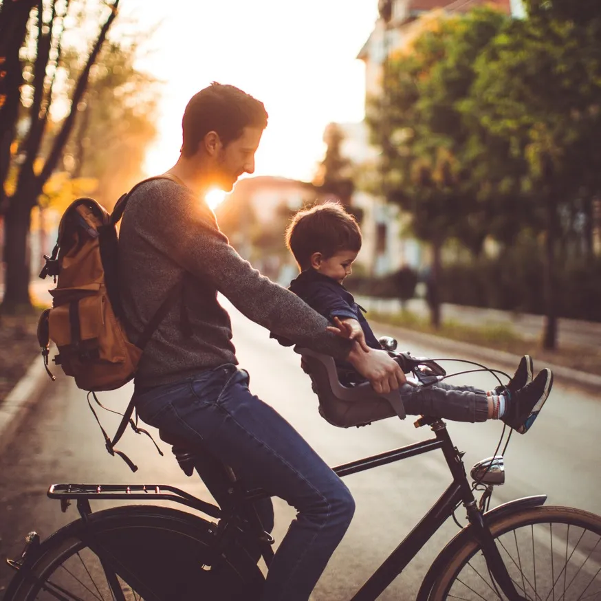 father and son riding bike at sunset alister valley apartment homes for rent in austin tx