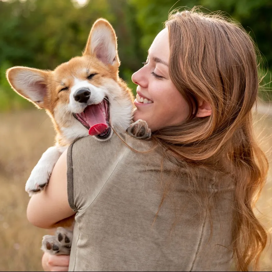 woman holding corgi dog and smiling outside modera falls church apartment homes for rent in va