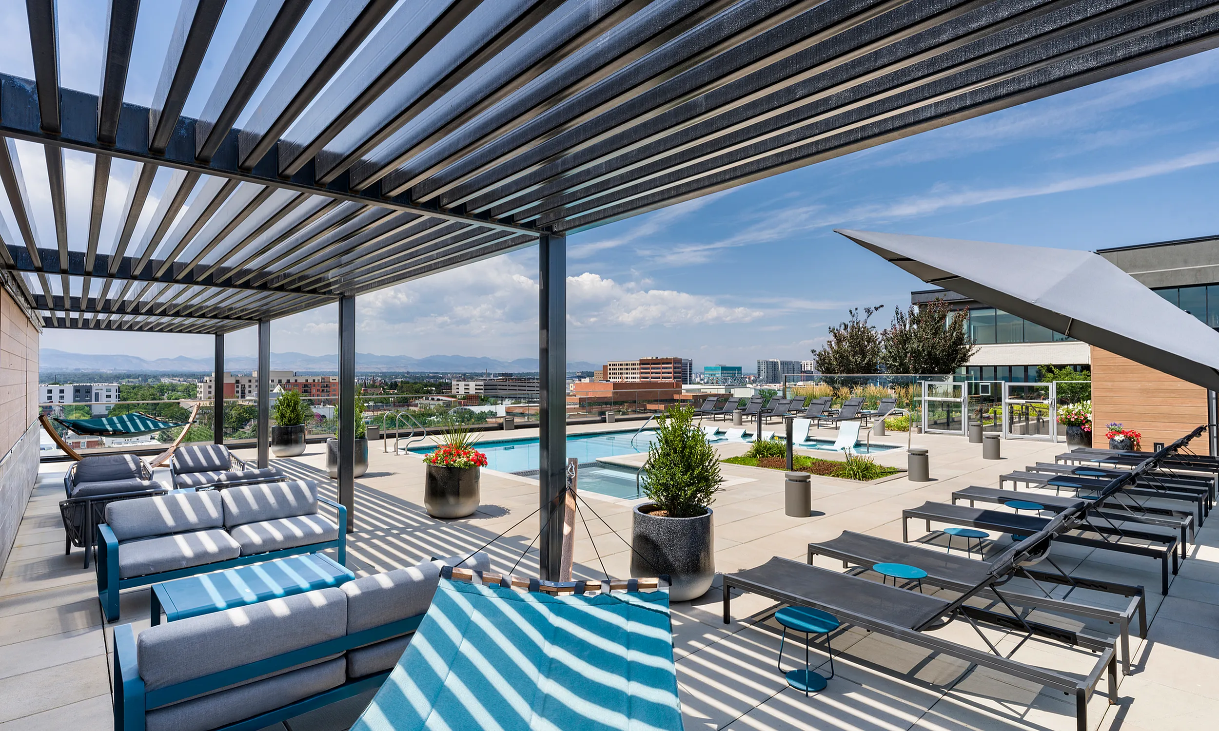Luxurious rooftop terrace featuring modern lounge seating, stylish pergola, and inviting swimming pool with stunning cityscape views.