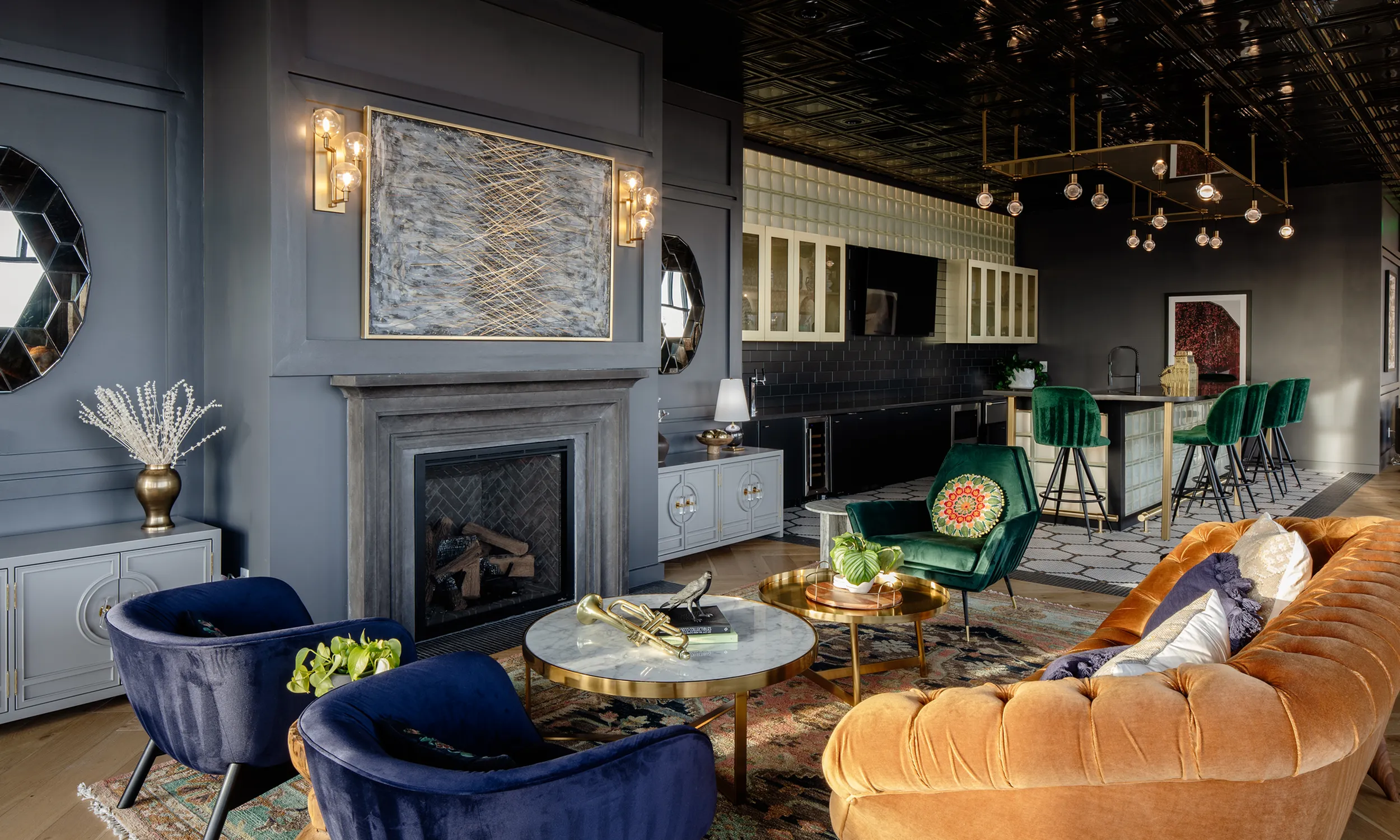 Luxurious community room featuring plush velvet seating, elegant lighting, and a stylish open kitchen with chic bar stools modera art park denver co
