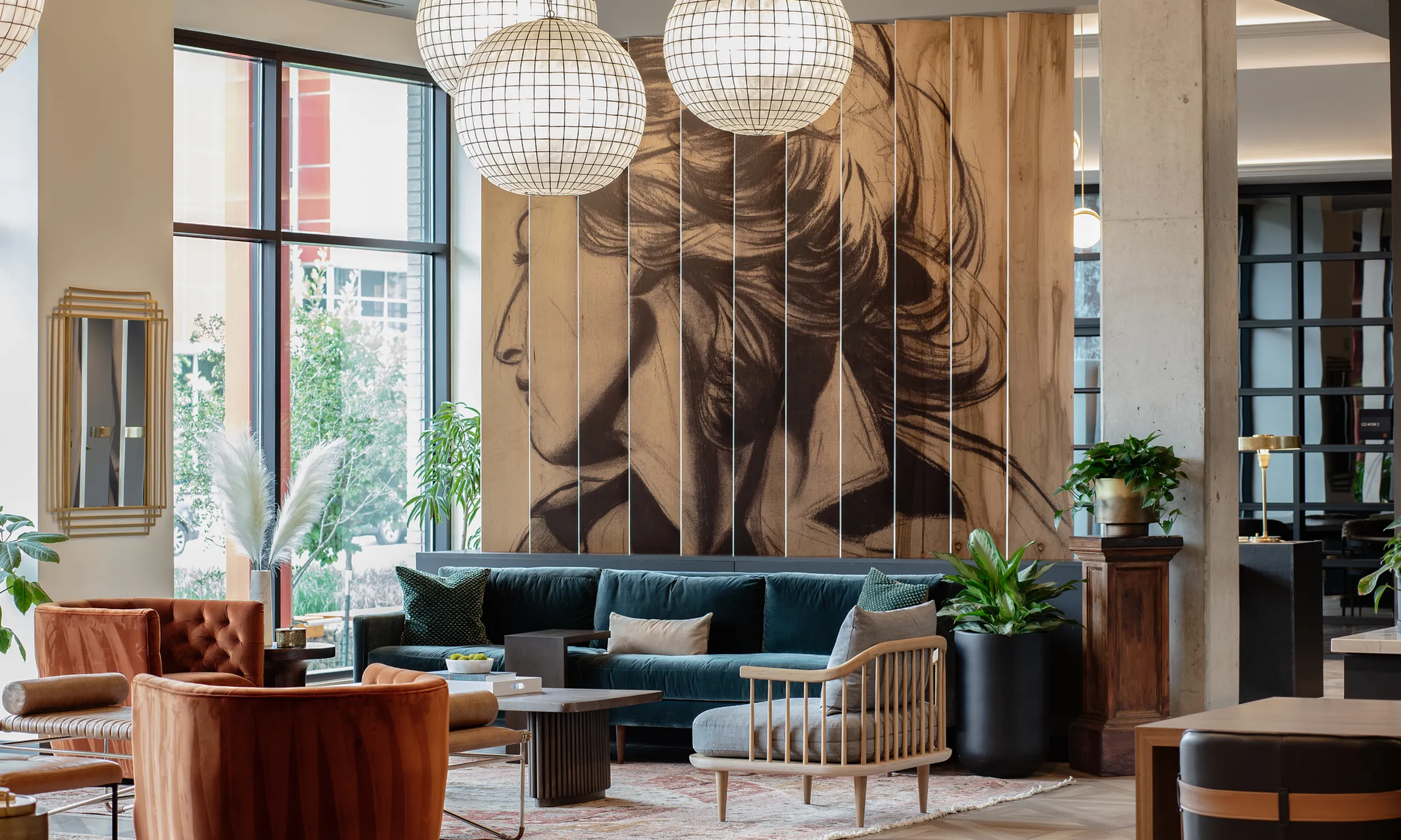 Chic, modern lounge with velvet green sofa, artistic wall mural, and elegant lighting, creating a sophisticated atmosphere modera art park denver co