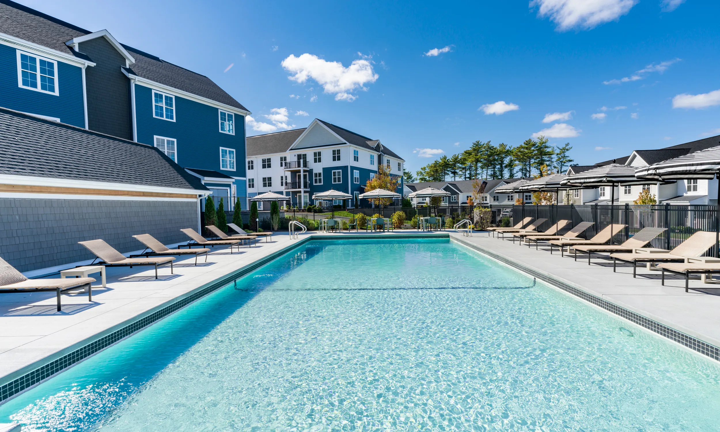 Luxurious apartment community with a sparkling pool, modern sun loungers, and stylish clubhouse modera south shore apartments for rent marshfield ma