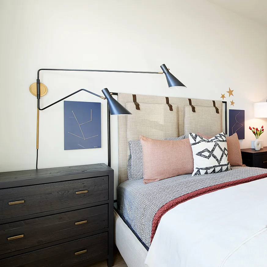 Elegant bedroom featuring a cozy bed with decorative pillows, modern lighting, and spacious walk-in closet.