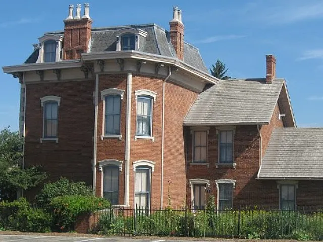 Charming brick apartment building with vintage architecture and lush garden, offering timeless elegance and a welcoming atmosphere.