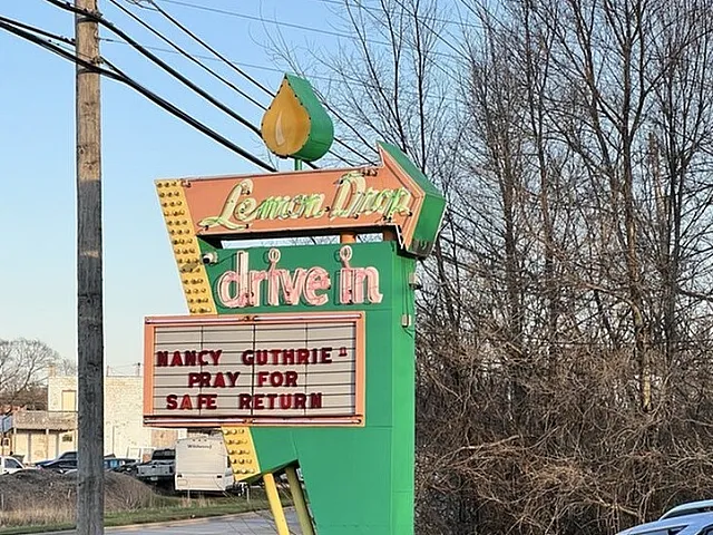 Charming vintage neon sign of Lemon Drop Drive-In amid a tranquil roadside setting, exuding nostalgic allure.