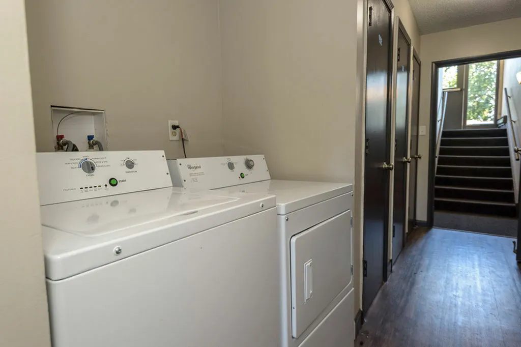 Modern laundry area featuring state-of-the-art appliances in a sleek, well-lit hallway setting.