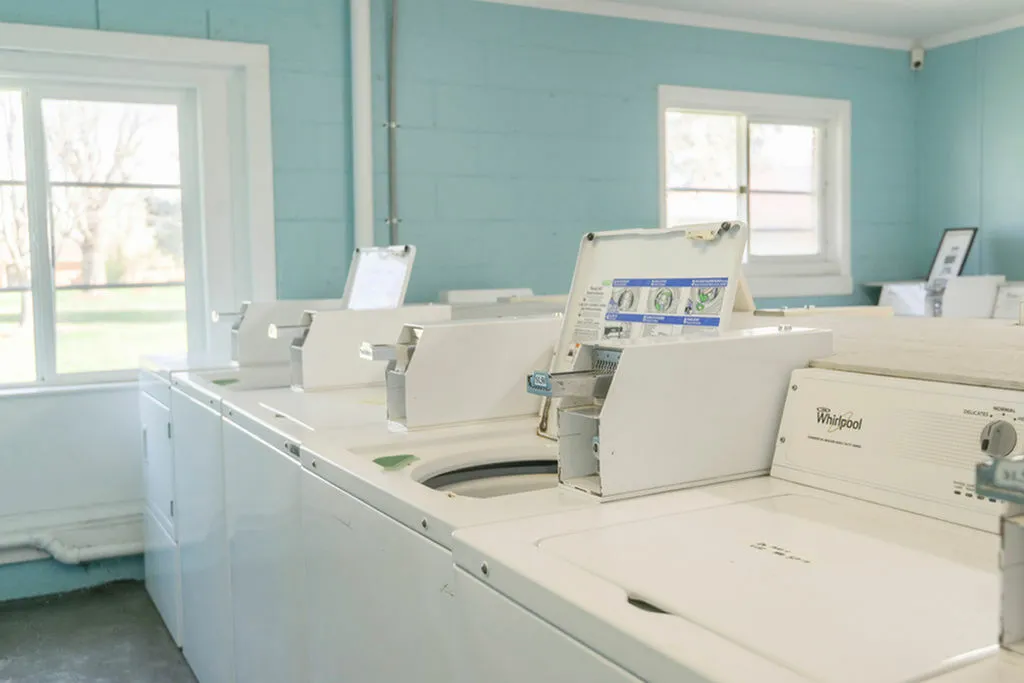 Bright and functional laundry room with modern washing machines and large windows, providing natural light and a welcoming atmosphere.