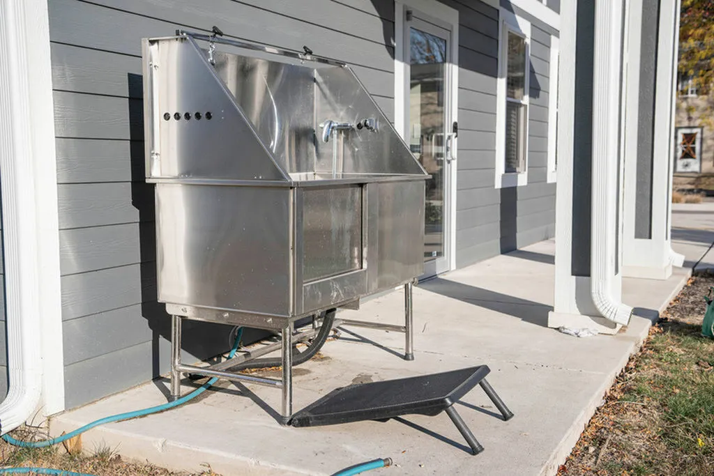 Outdoor pet washing station on a spacious patio with modern gray siding, perfect for pet-friendly living.