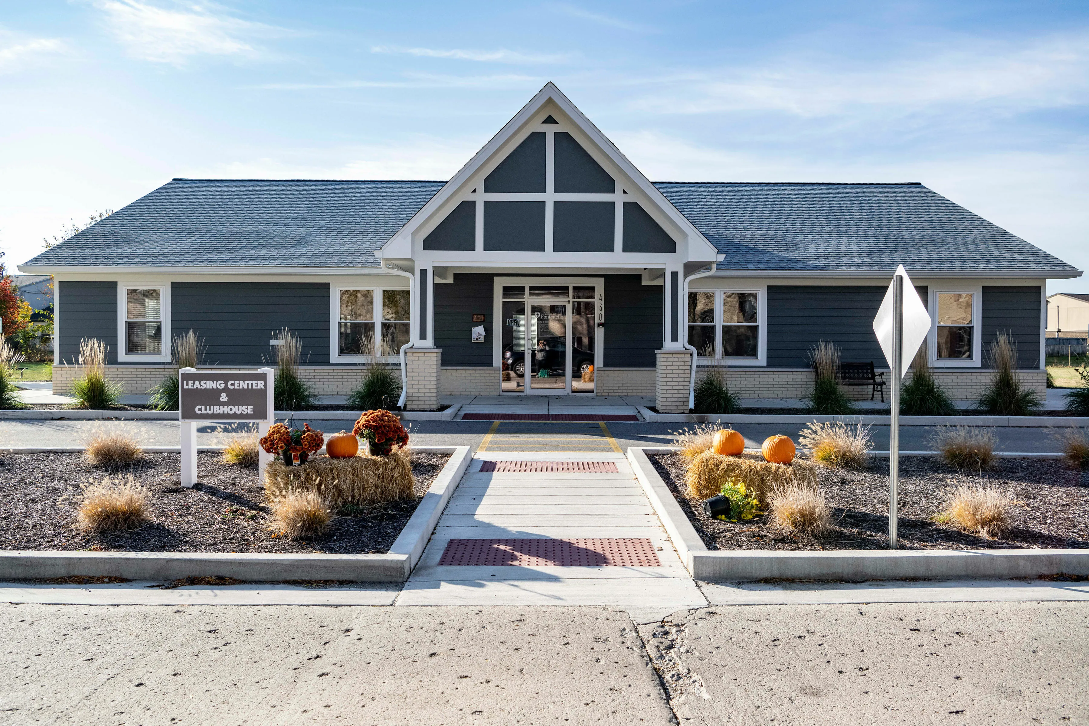 Charming leasing center and clubhouse entrance with attractive autumn decor, pumpkins, and welcoming ambiance.