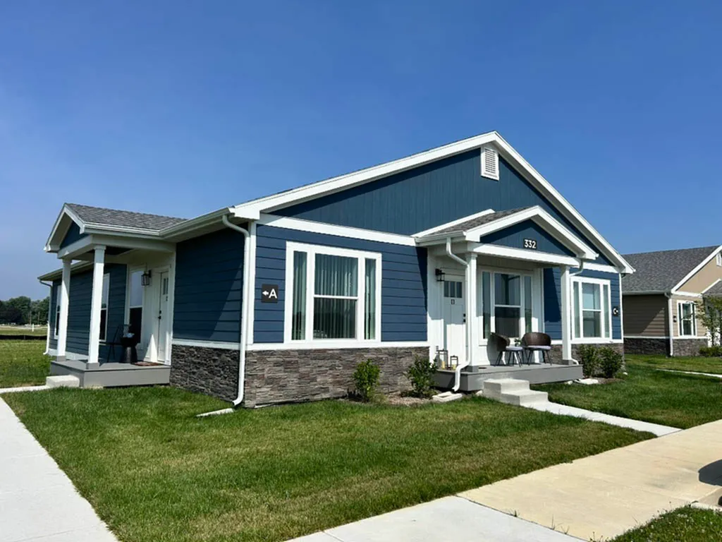 Charming blue and white single-story house with a welcoming front porch and well-maintained lawn.