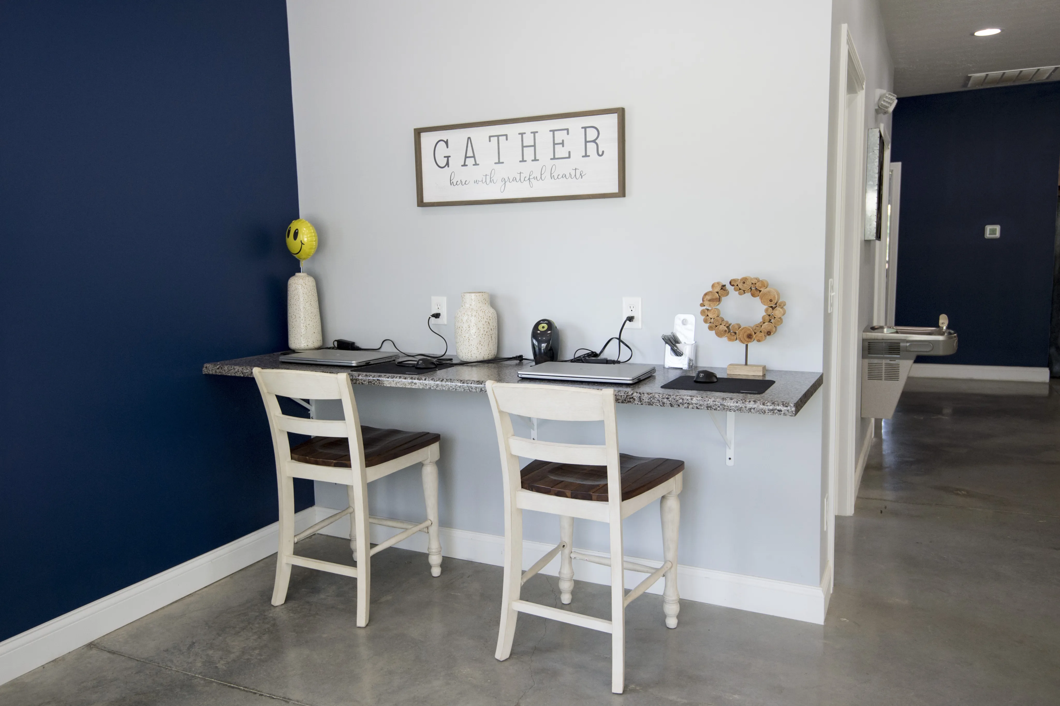 Modern workspace with sleek granite desk, elegant decor, and cozy seating, ideal for productivity.