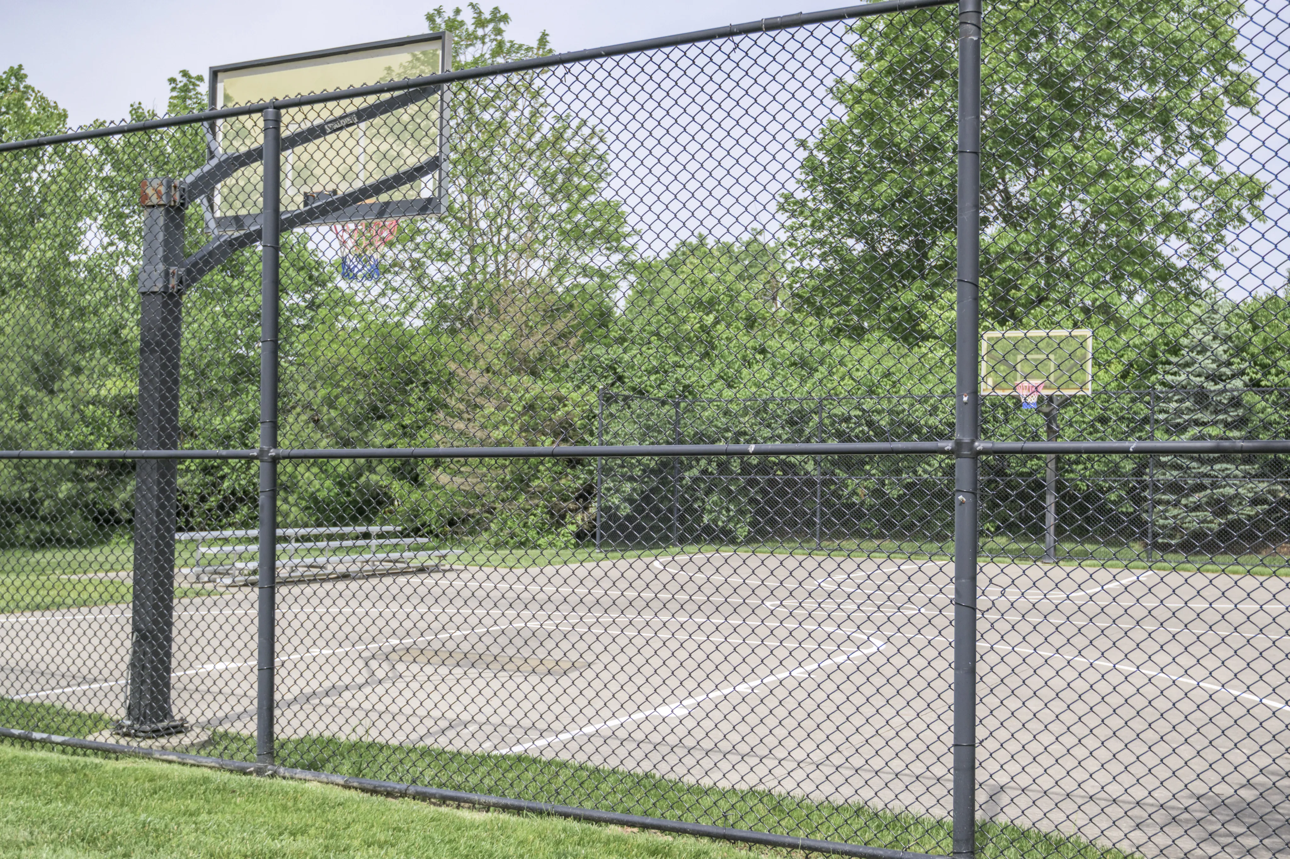 Inviting outdoor basketball court surrounded by lush greenery, offering a perfect space for recreation and sports enthusiasts.