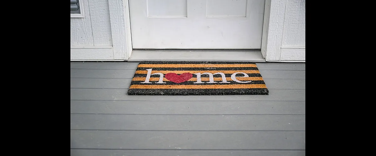 Inviting doorstep with a charming doormat reading 'home,' featuring a cozy heart design, perfect for a warm welcome.