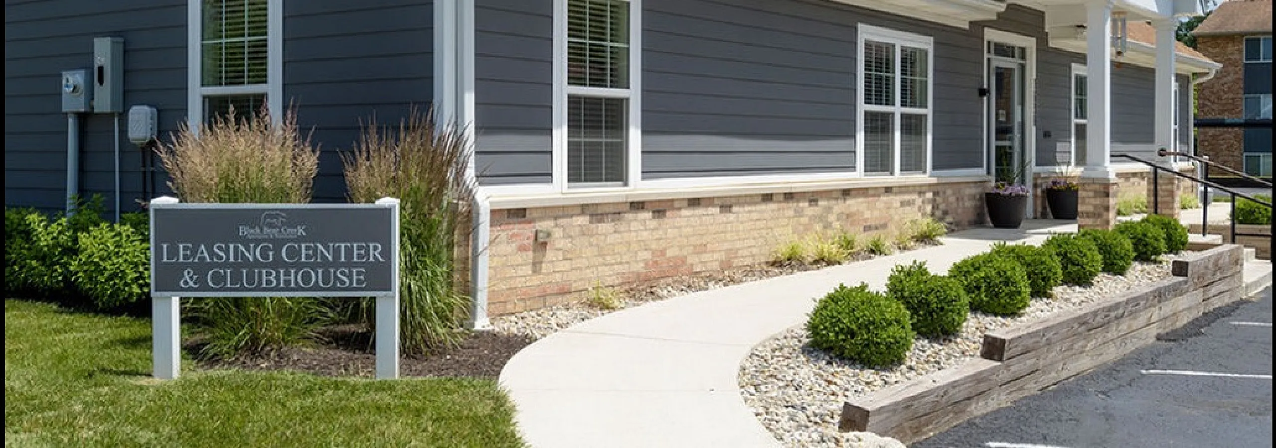 Inviting leasing center and clubhouse with modern architecture, well-maintained landscaping, and a welcoming entrance pathway.