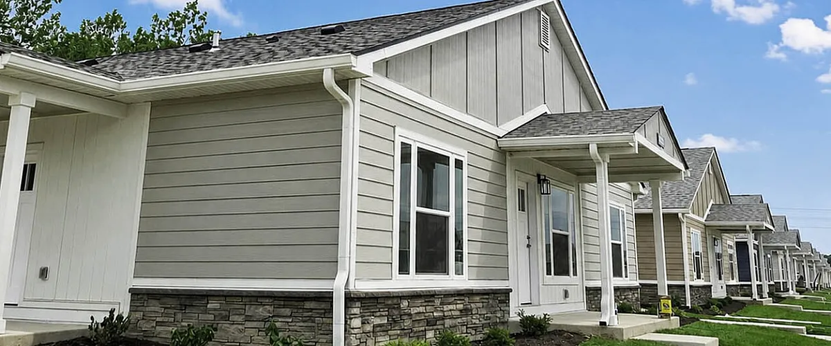 Charming row of modern homes with manicured lawns and bright blue skies, perfect for family living.