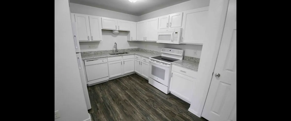 Bright and modern kitchen with sleek white cabinets, granite countertops, and stainless steel appliances.